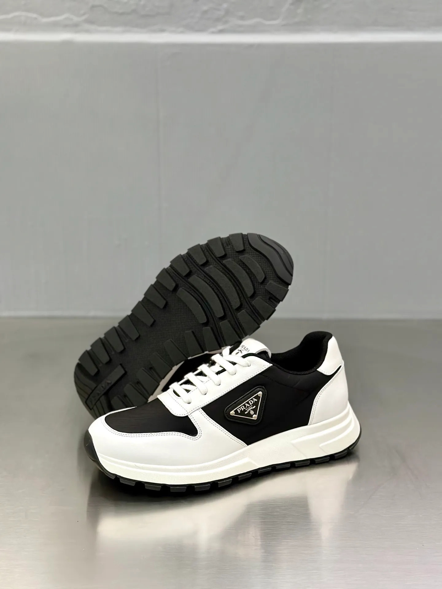 💰740 Prada/Prada men's new mesh stitching sneakers. This sneaker presents a modern version, reinterpreting the brand's archive style with clean lines and smooth details. The shoes are made of calf leather and technical fabric, with a triangular metal logo on the outside, bright TPU decoration on the heel, and a longer and padded inner heel design for a more comfortable fit. The tongue is decorated with a silk-screen logo, and is paired with a hollow rubber sole on the heel. The full cowhide lining comes standard with logo cowhide foot pads, making the upper foot taller, more comfortable, and versatile! Comes with full original packaging! Size: 39-40-41-42-43-44 standard leather shoe size (45 can be customized and does not support returns)